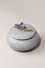 Porcelain Muse luxury porcelain jar with butterfly and branch detail in metallic tones by Atelier Carrousel