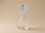 Nassim luxury glass bottle with blue purple sculpted floral cap by Atelier Carrousel